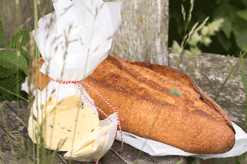 boter van bloemetjes in papieren zak met brood